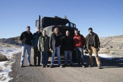 Photograph of people standing in front of the vehicle